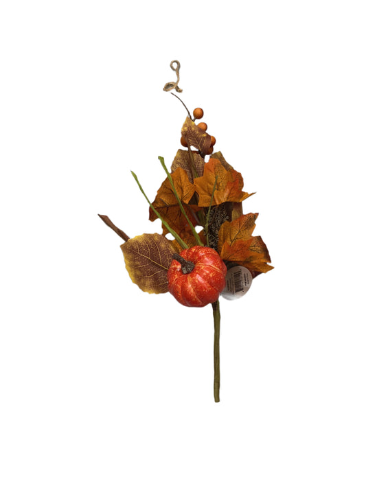 Artificial pumpkin and leaf decoration on a textured gray surface